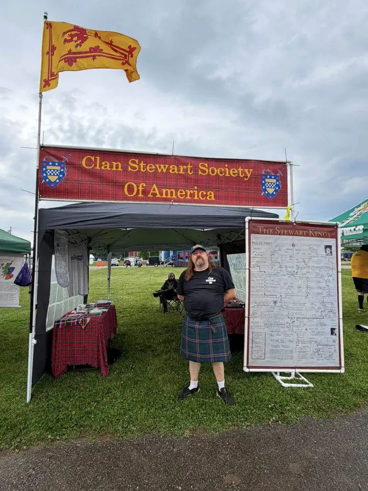 Clan Stewart Society of America tent with a tartan banner, family-history display, and Scottish flag.