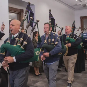 Pipers and drummers parade through City Hall at pre-parade reception