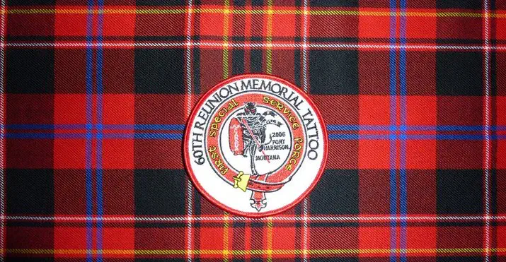 A 60th Reunion Memorial Tattoo patch marked 2006, Fort Harrison, Montana, displayed on tartan fabric.