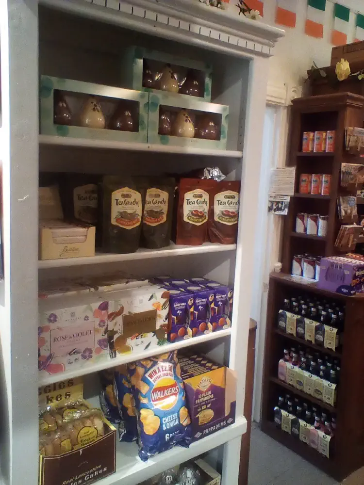 Tea, biscuits, crisps, and other imported groceries on shop shelves.