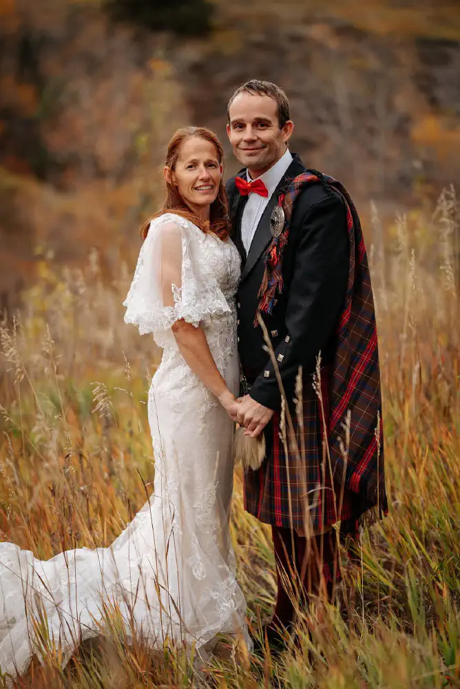 A wedding couple outdoors, with tartan Highland dress.